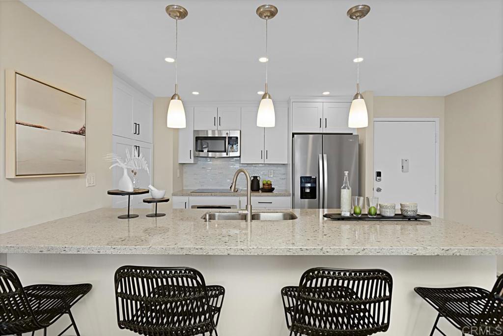 2500 Torrey Pines Road, Unit 503 La Jolla, CA 92037 - Photo 10 of 46 a kitchen with kitchen island granite countertop a sink and a refrigerator