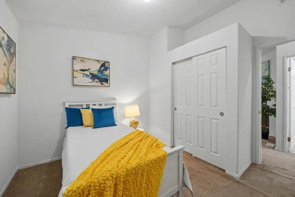 a bedroom with a bed and a painting on the wall