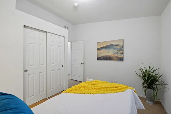 a bedroom with a bed and a potted plant