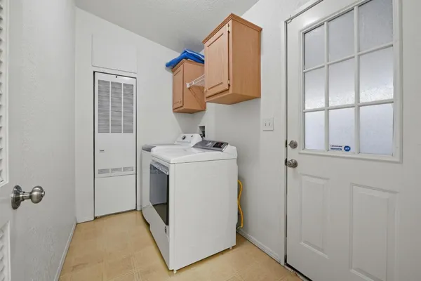a utility room with cabinets washer and dryer
