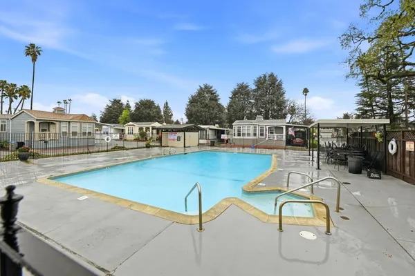 a view of a swimming pool with outdoor seating and plants