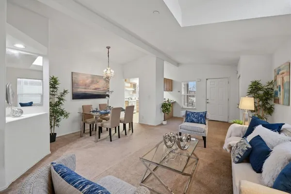 a living room with furniture a dining table and a potted plant