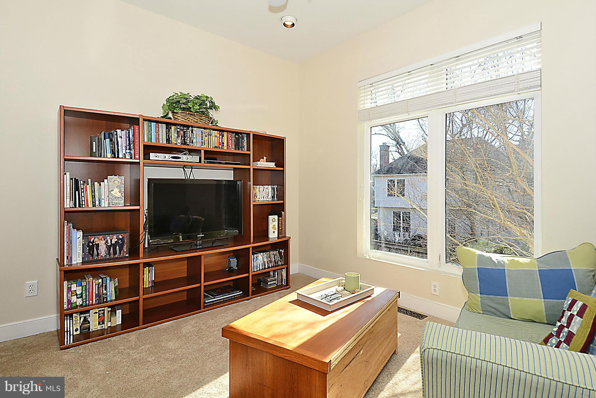 823 Rowen Road Silver Spring, MD 20910 - Photo 12 of 30 a living room with furniture a flat screen tv and a book shelf