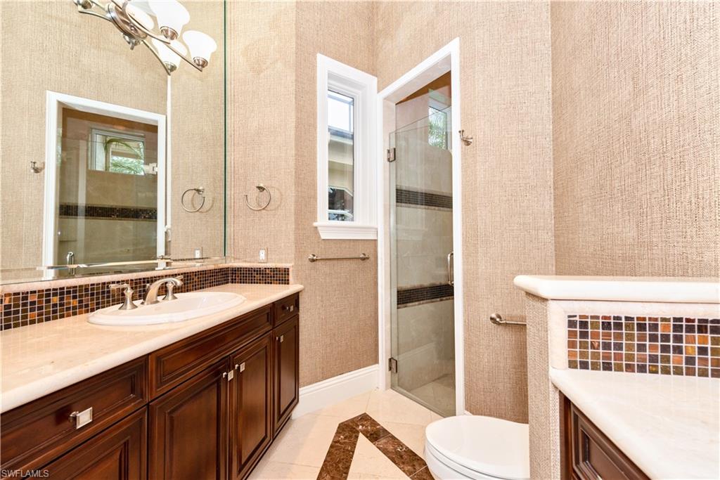 3110 Dahlia Way Naples, FL 34105 - Photo 13 of 35 a bathroom with a sink a toilet and shower
