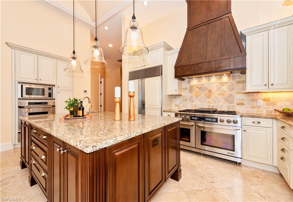 3110 Dahlia Way Naples, FL 34105 - Photo 18 of 35 a kitchen with stainless steel appliances granite countertop a stove a sink and a microwave