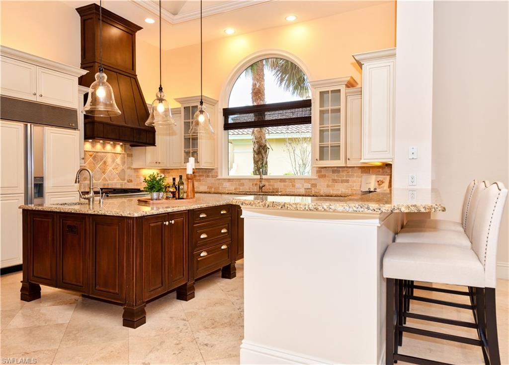 3110 Dahlia Way Naples, FL 34105 - Photo 19 of 35 a kitchen with stainless steel appliances a sink a stove and a window