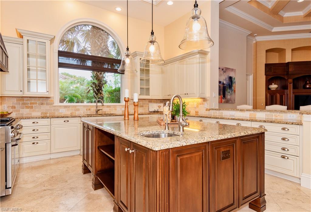 3110 Dahlia Way Naples, FL 34105 - Photo 20 of 35 a kitchen with kitchen island granite countertop a sink appliances cabinets and a large window