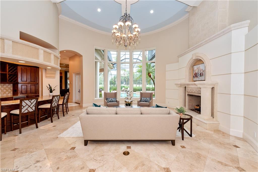 3110 Dahlia Way Naples, FL 34105 - Photo 3 of 35 a living room with furniture a fireplace and a chandelier