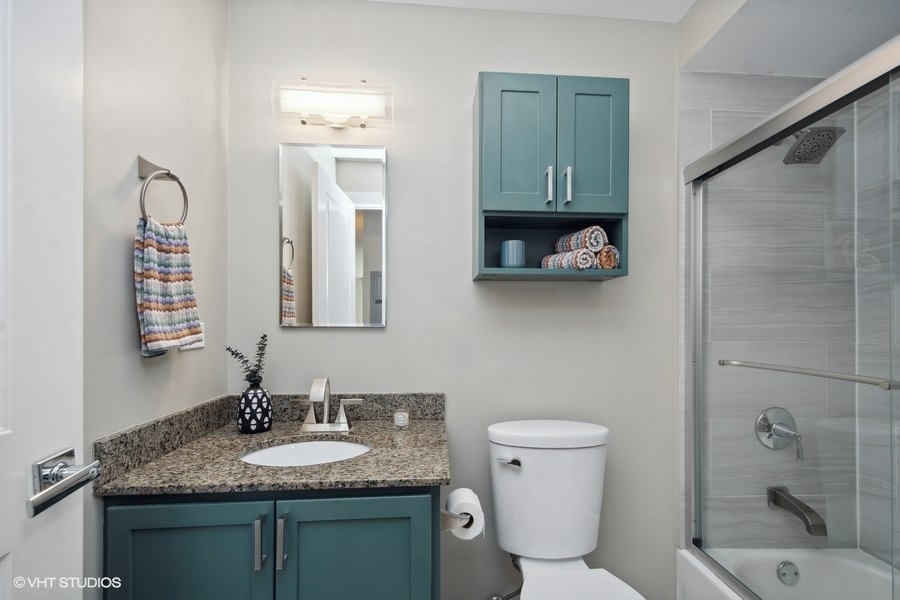 3033 North Sheridan Road, Unit 1201 Chicago, IL 60657 - Photo 12 of 16 a bathroom with a granite countertop sink toilet and shower