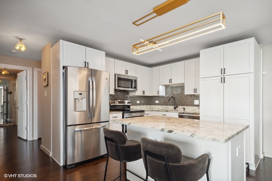 3033 North Sheridan Road, Unit 1201 Chicago, IL 60657 - Photo 5 of 16 a kitchen with stainless steel appliances a refrigerator and a stove top oven