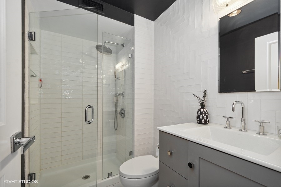 3033 North Sheridan Road, Unit 1201 Chicago, IL 60657 - Photo 9 of 16 a bathroom with a sink a toilet and shower