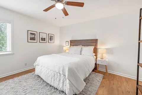 a bedroom with a bed and painting on the wall
