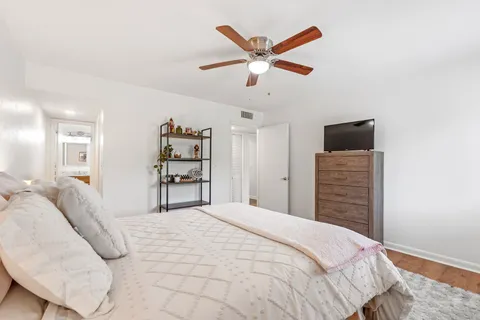 a bedroom with a large bed and a chandelier