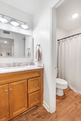 a bathroom with a granite countertop sink toilet and shower