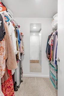 a view of walk in closet with clothes and shoes