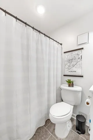 a white toilet sitting next to a shower curtain