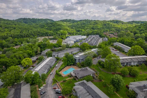 a view of a house with a yard and mountain view in back