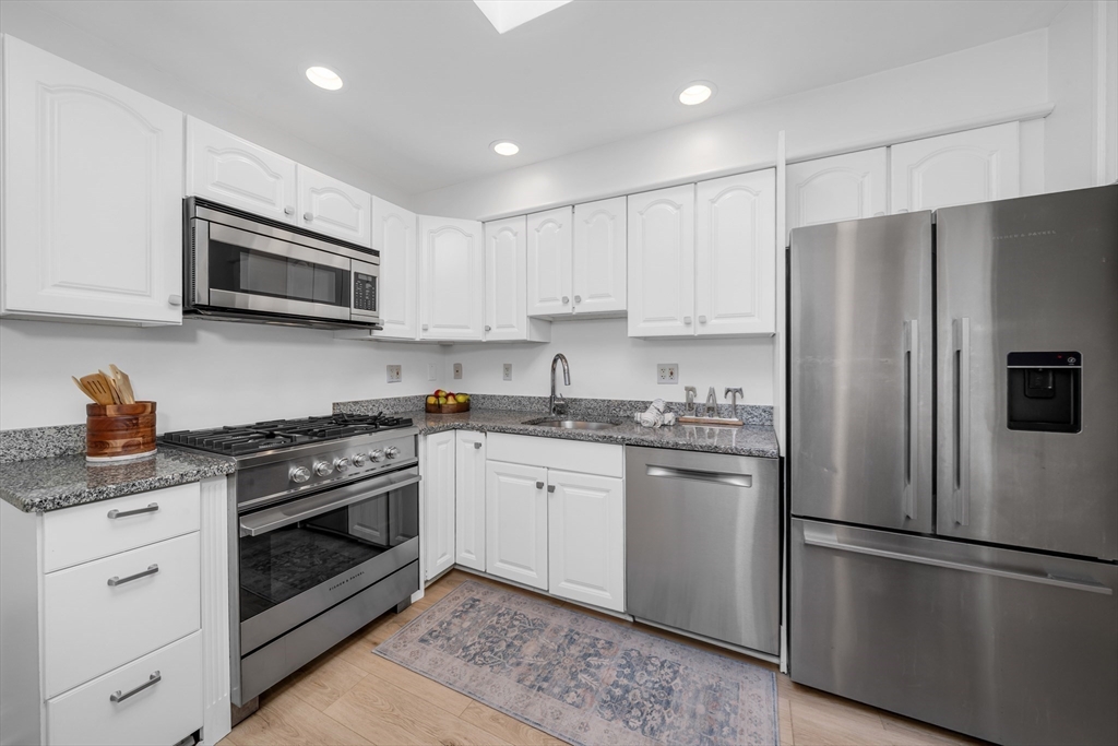 93 Baldwin Street, Unit 1 Boston, MA 02129 - Photo 11 of 30 a kitchen with stainless steel appliances granite countertop a refrigerator stove a sink and a microwave