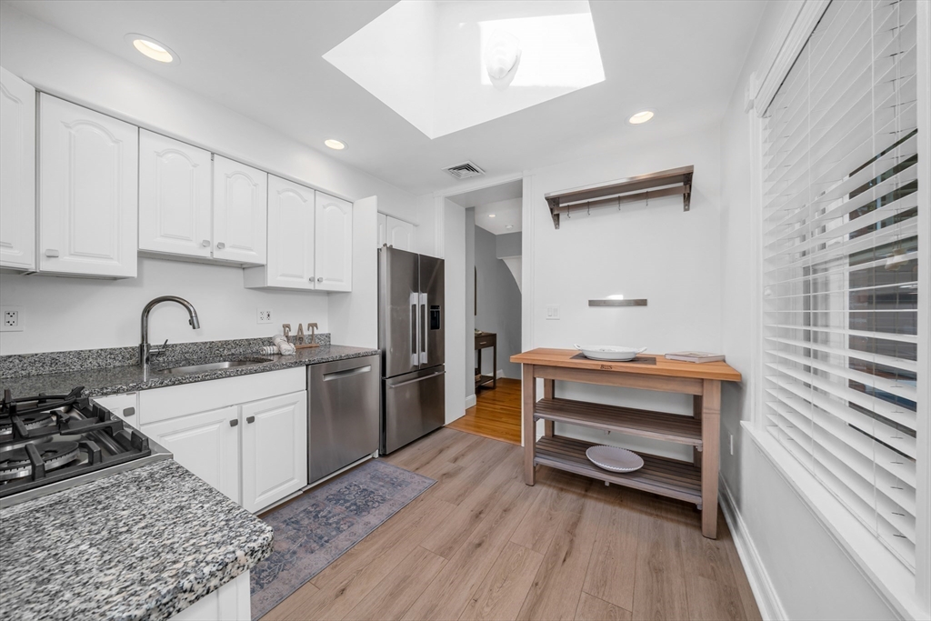 93 Baldwin Street, Unit 1 Boston, MA 02129 - Photo 12 of 30 a kitchen with a sink a stove a refrigerator and cabinets