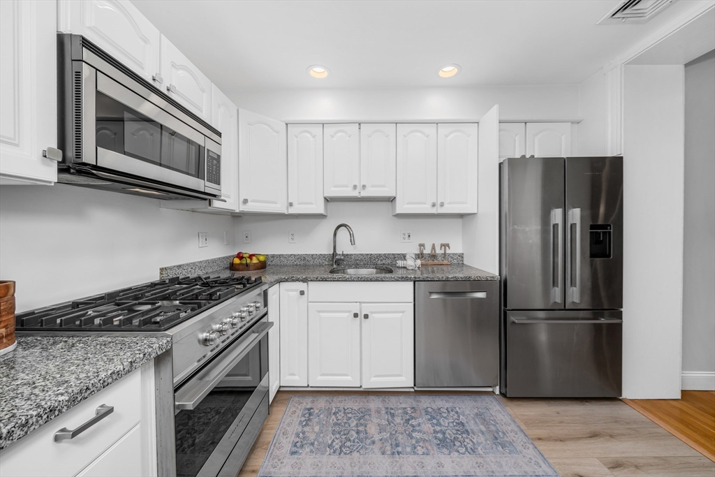 93 Baldwin Street, Unit 1 Boston, MA 02129 - Photo 13 of 30 a kitchen with a sink stove and refrigerator