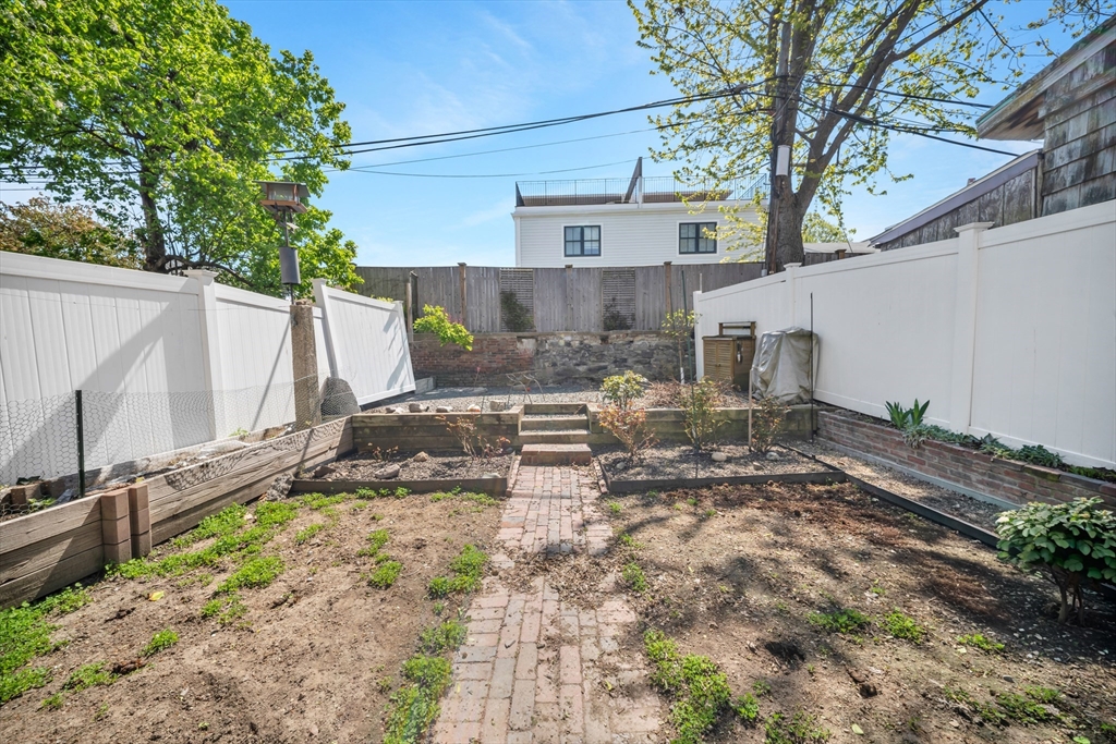 93 Baldwin Street, Unit 1 Boston, MA 02129 - Photo 26 of 30 a view of a backyard with wooden fence and a large tree