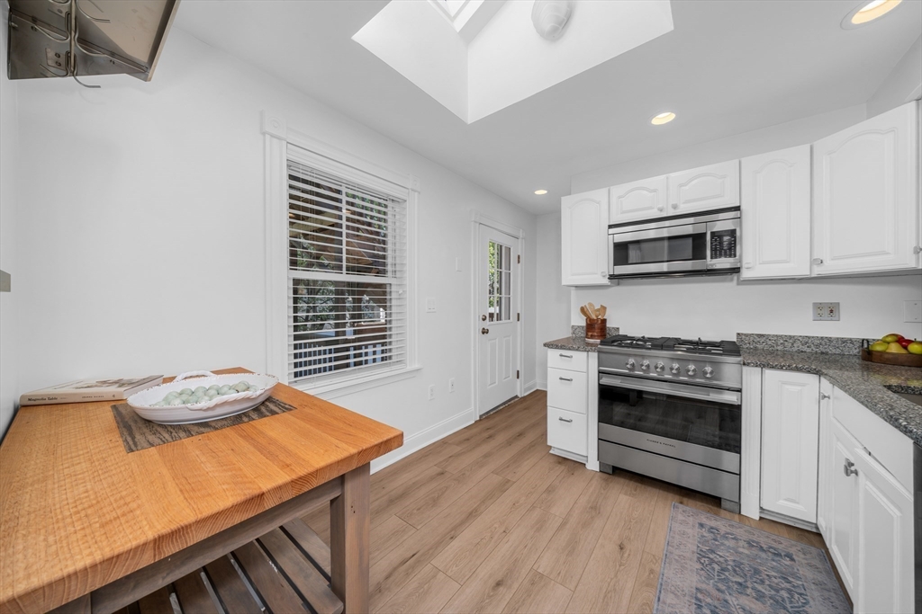 93 Baldwin Street, Unit 1 Boston, MA 02129 - Photo 10 of 30 a kitchen with stainless steel appliances wooden floor and a stove top oven