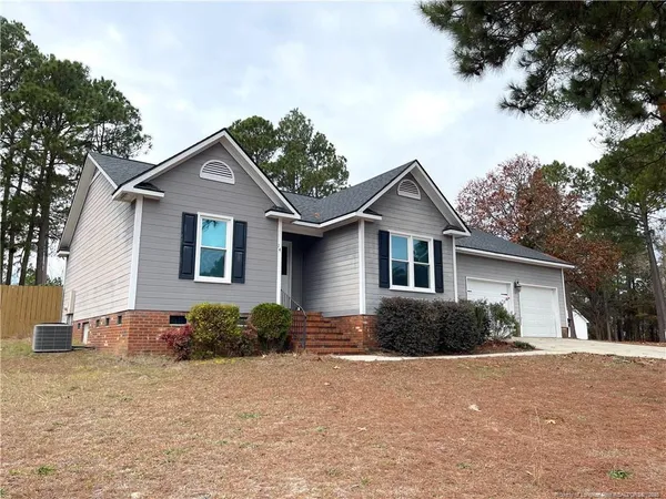 a front view of house with yard and trees around