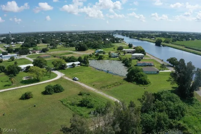 an aerial view of a residential houses with outdoor space and lake view