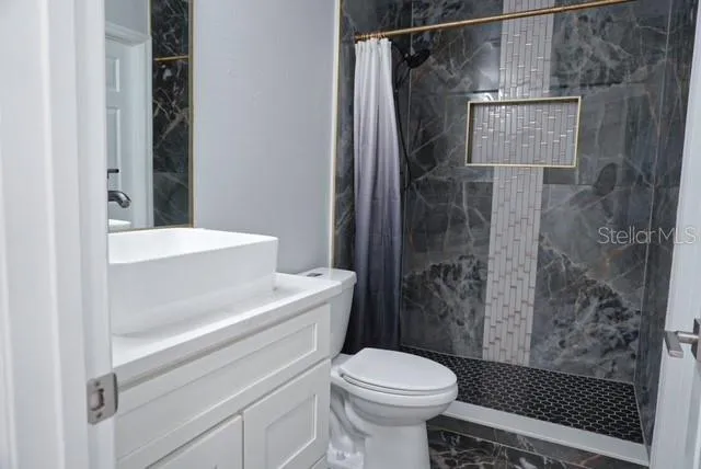 a view of an empty room with wooden floor and windows