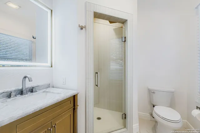 a bathroom with a granite countertop sink toilet and shower
