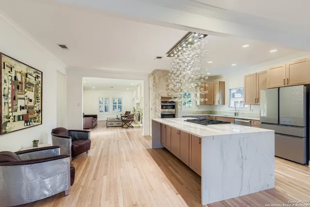 a large kitchen with stainless steel appliances granite countertop a lot of counter space and wooden floors