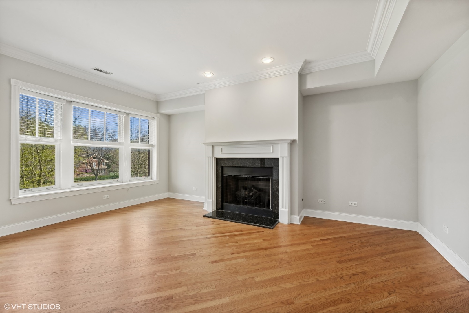 1016 Main Street, Unit 2 Evanston, IL 60202 - Photo 3 of 18 an empty room with wooden floor fireplace and windows