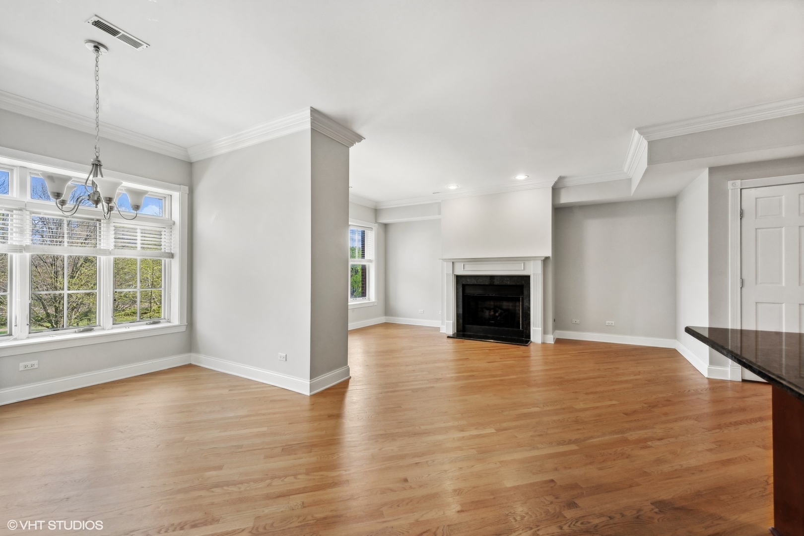 1016 Main Street, Unit 2 Evanston, IL 60202 - Photo 4 of 18 a view of an empty room with wooden floor fireplace and a window