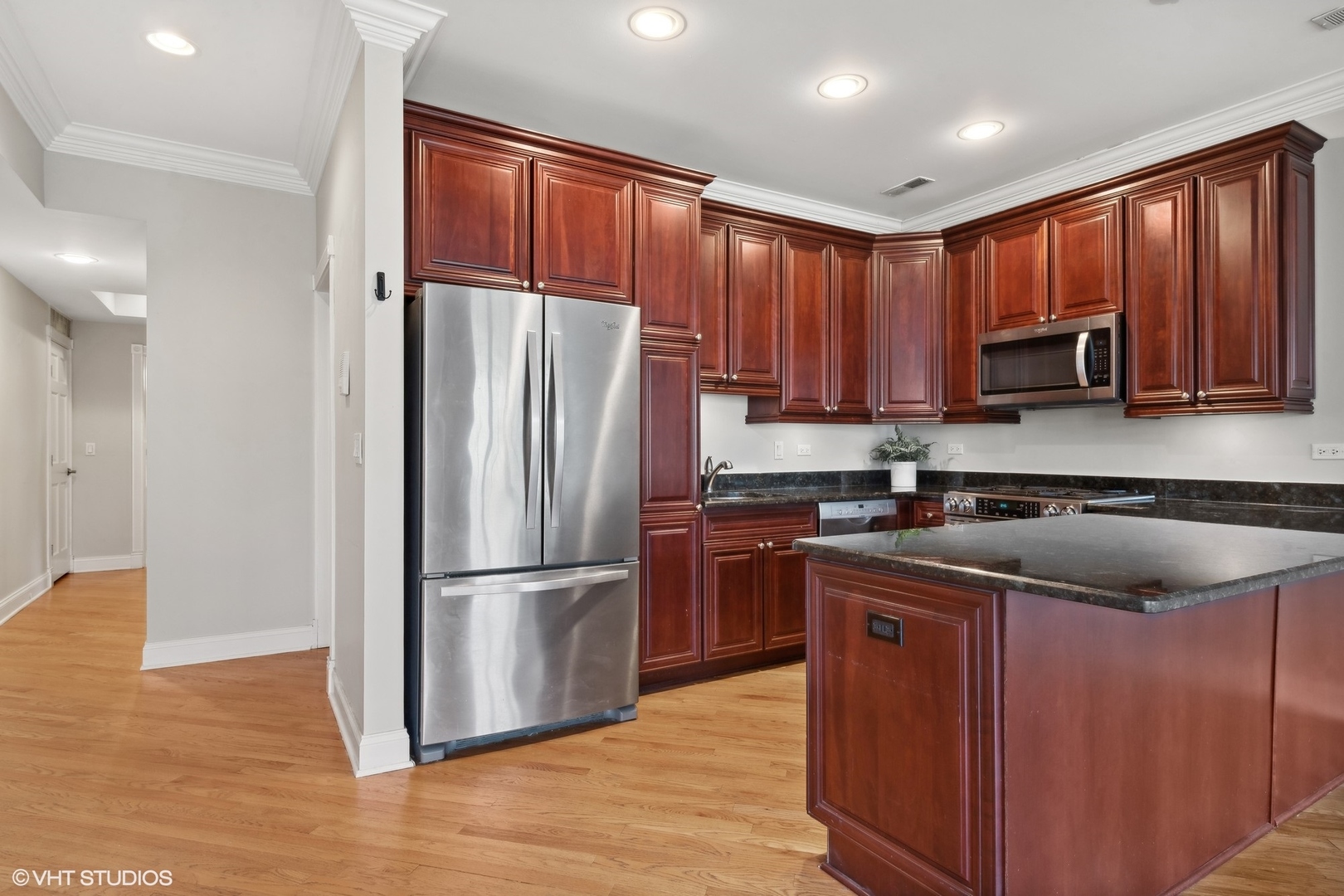 1016 Main Street, Unit 2 Evanston, IL 60202 - Photo 6 of 18 a kitchen with kitchen island granite countertop wooden floors stainless steel appliances a sink and a window