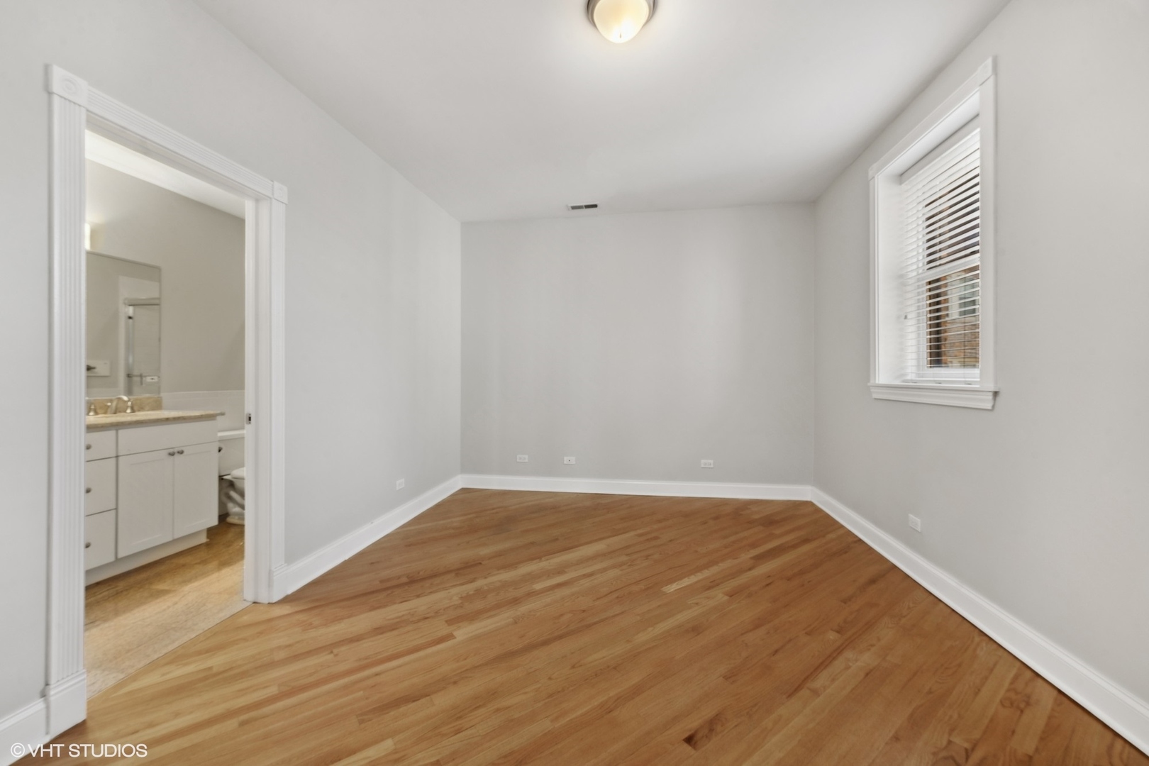 1016 Main Street, Unit 2 Evanston, IL 60202 - Photo 9 of 18 wooden floor in an empty room with a window