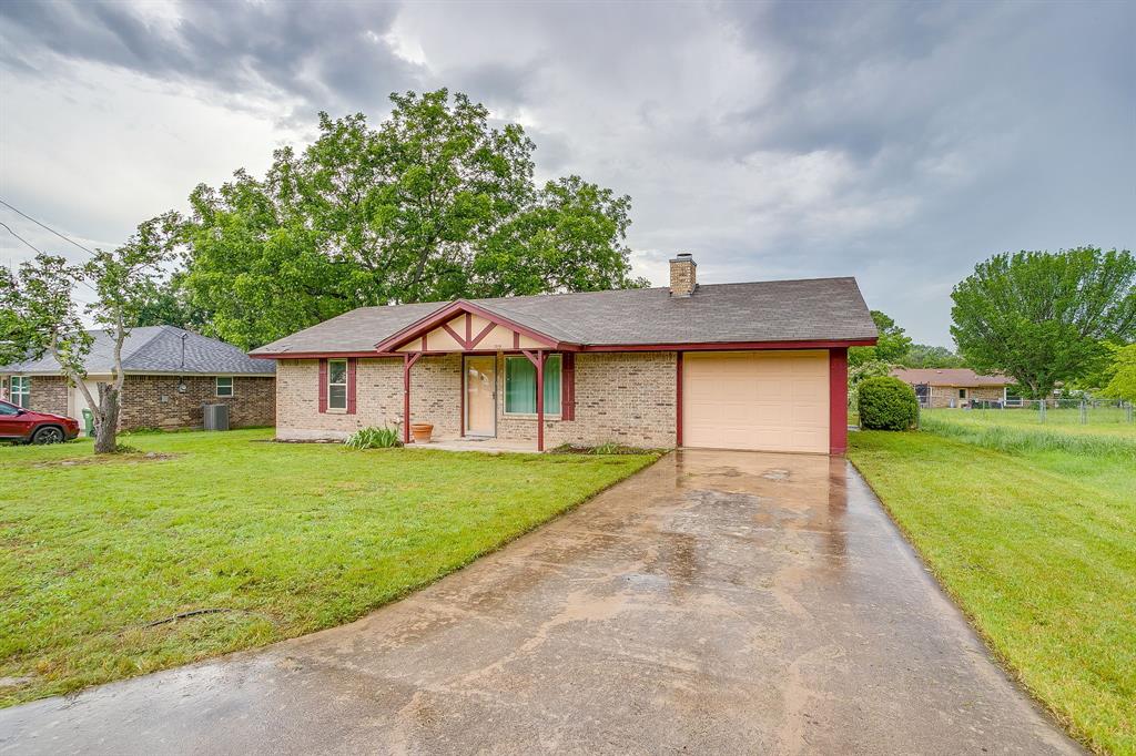709 North Ave B Springtown, TX 76082 - Photo 5 of 32 a front view of a house with garden