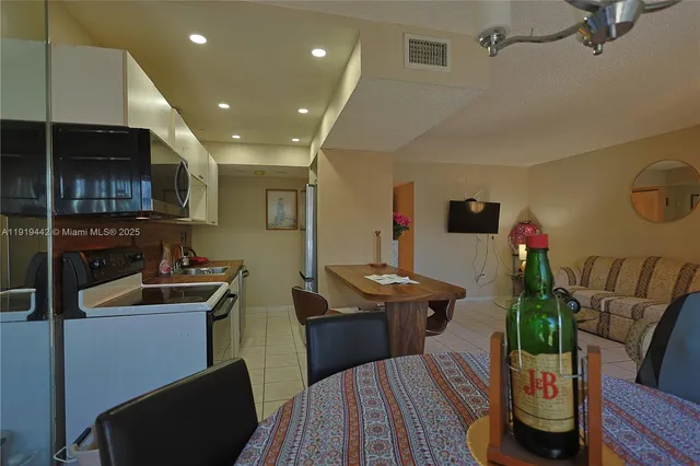 a living room with furniture a flat screen tv and kitchen view