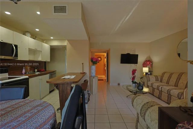 a view of a livingroom with furniture a dinning room and windows