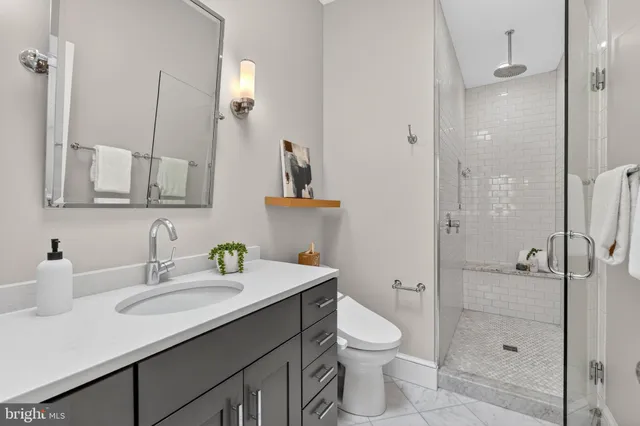 a bathroom with a granite countertop sink toilet and shower