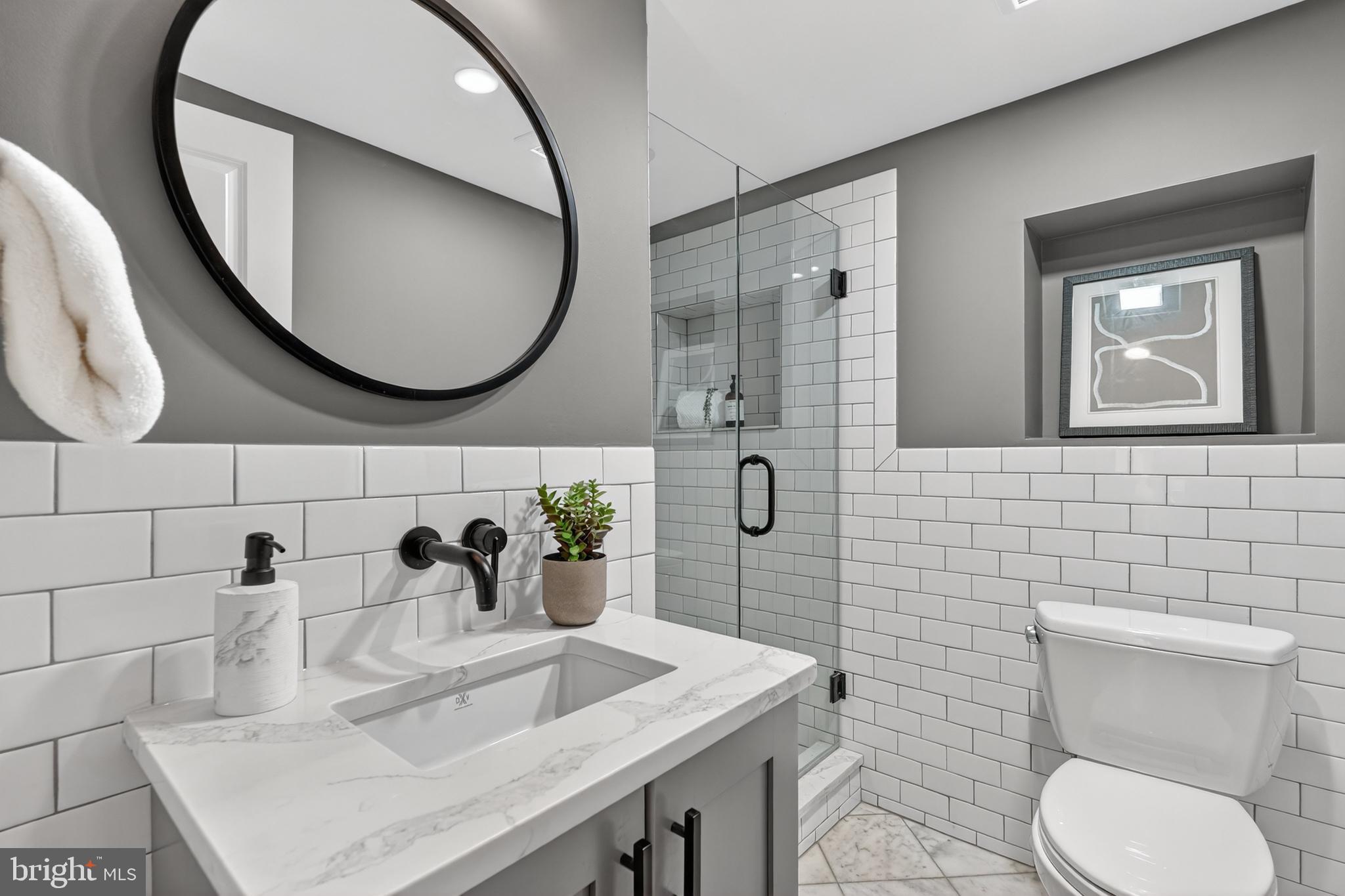 114 4th Street Northeast Washington, DC 20002 - Photo 34 of 40 a bathroom with a granite countertop toilet sink and mirror