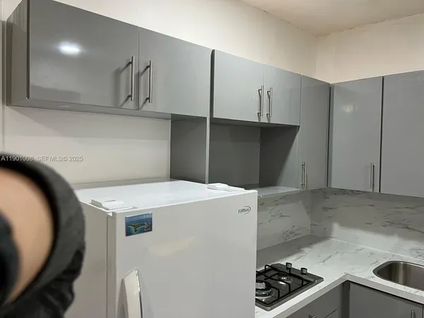 a kitchen with granite countertop a sink a stove and a refrigerator