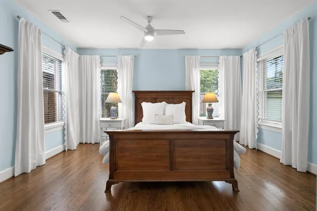 a view of a bedroom with wooden floor and a window