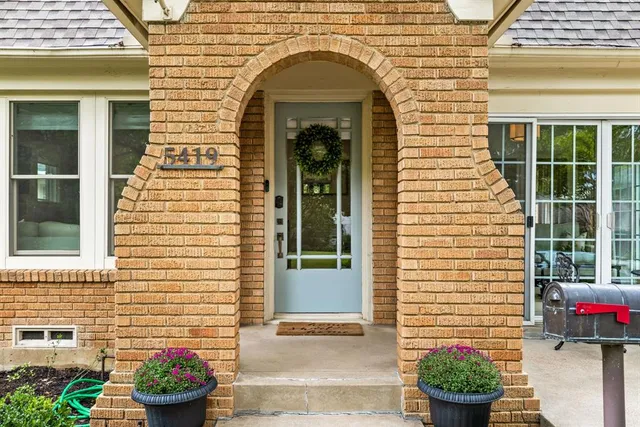 a front view of a house with a potted plant
