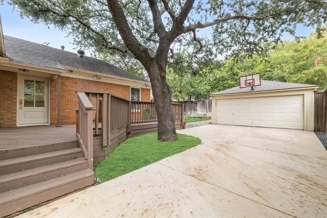 a view of a house with a yard and large tree