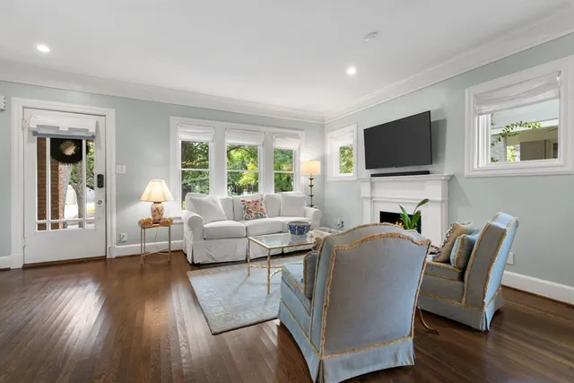 a living room with furniture a flat screen tv and a fireplace