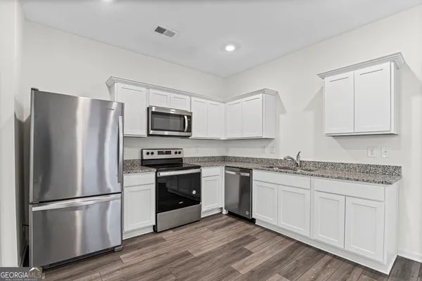 a kitchen with stainless steel appliances granite countertop a refrigerator stove and microwave