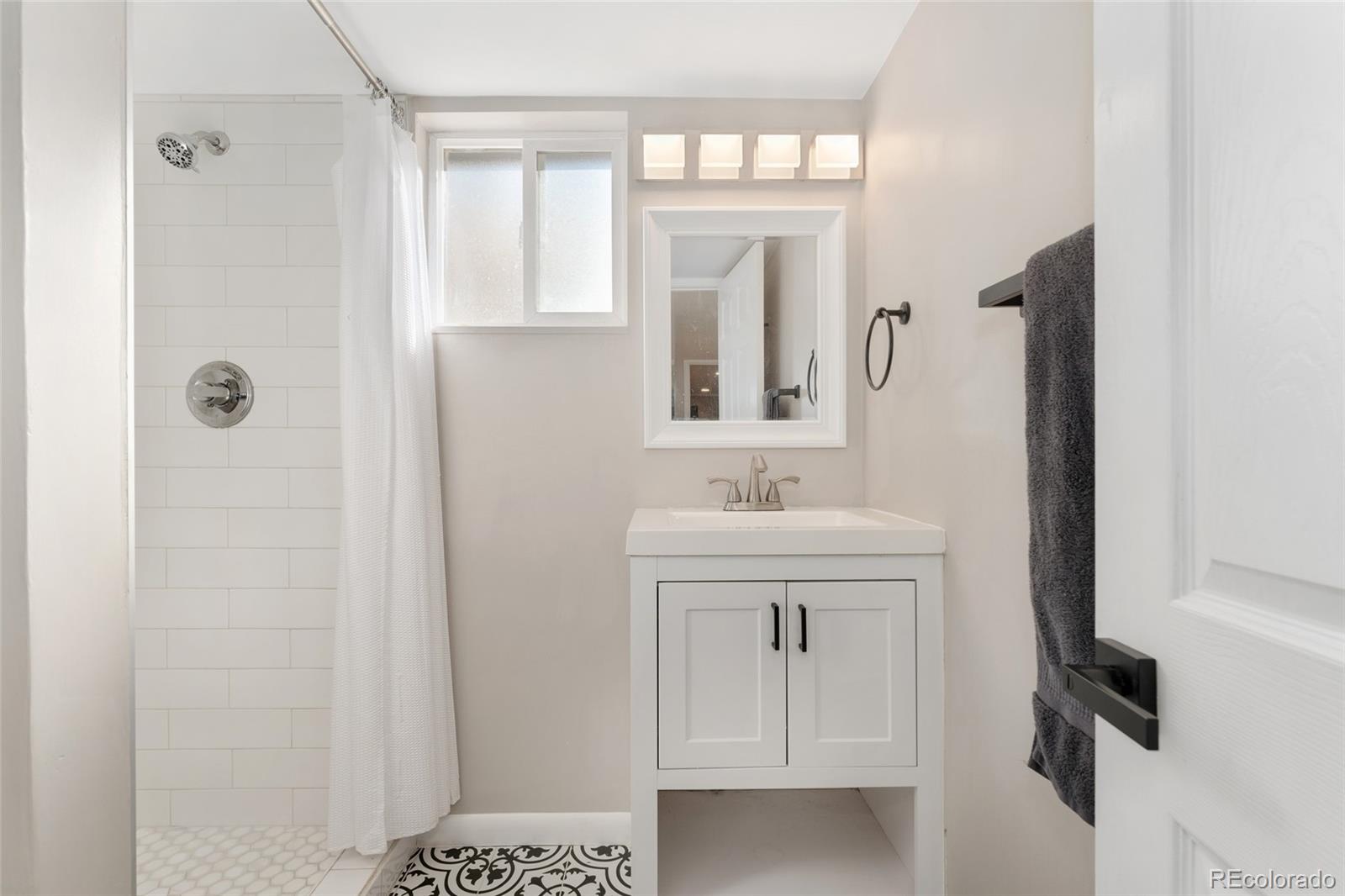 1528 Harrison Street Denver, CO 80206 - Photo 24 of 45 a bathroom with a sink a vanity and a mirror