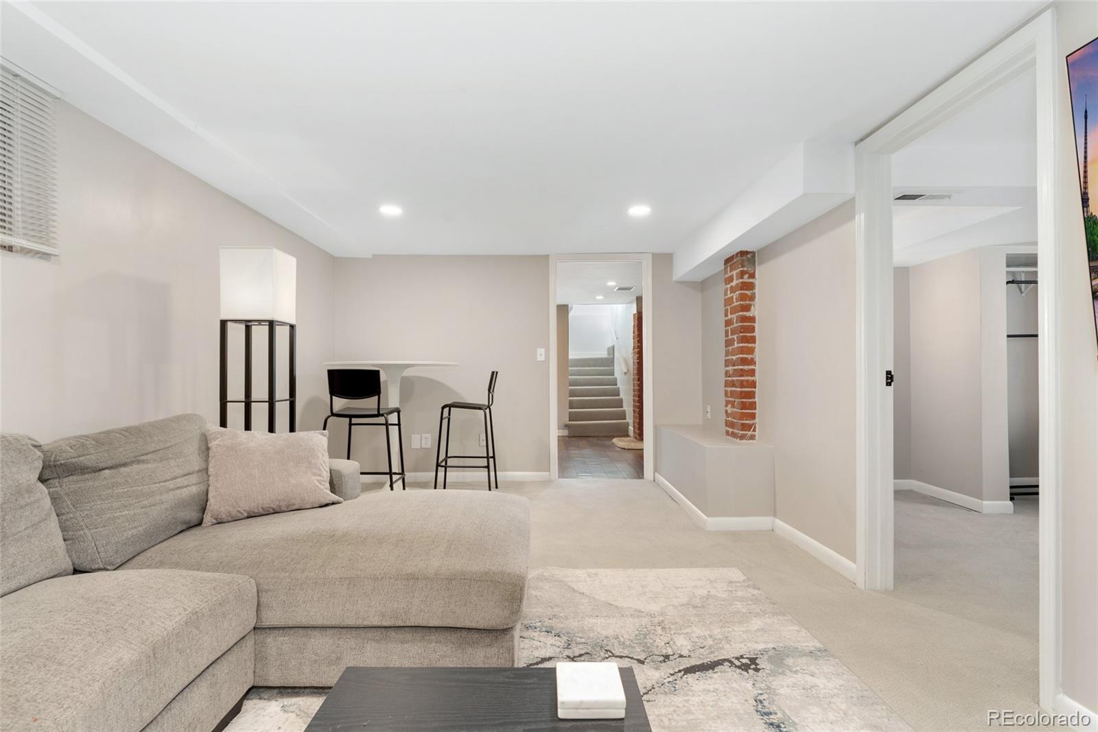 1528 Harrison Street Denver, CO 80206 - Photo 27 of 45 a living room with furniture a ceiling fan and a rug