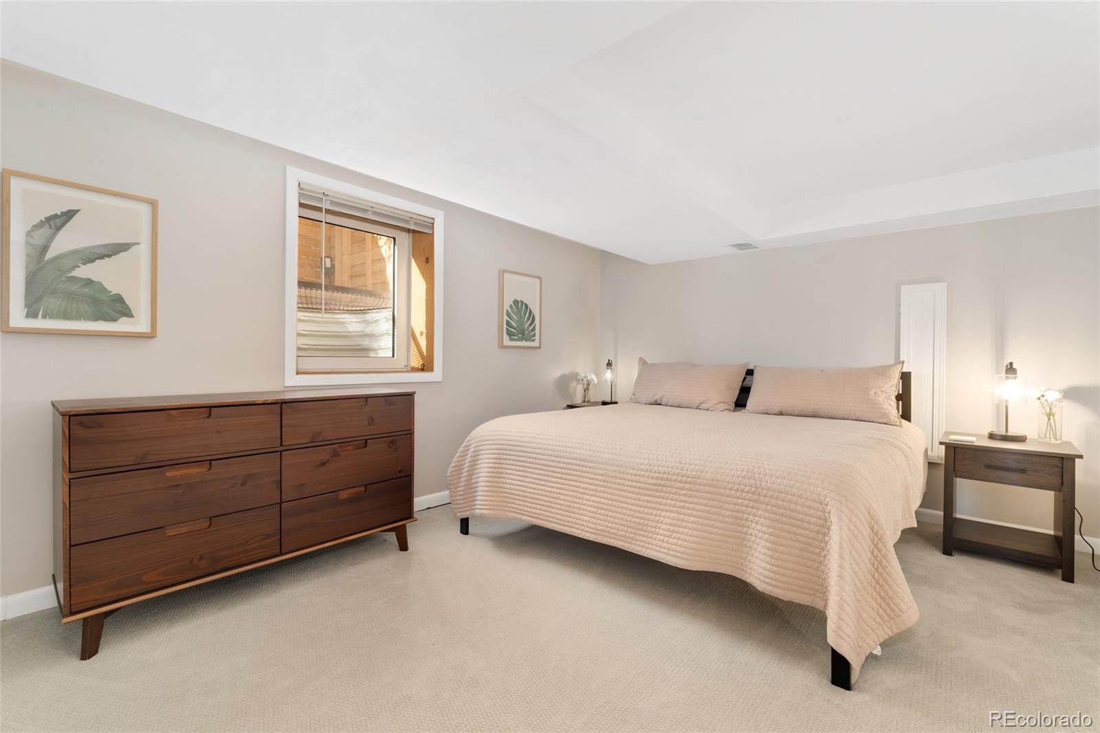 1528 Harrison Street Denver, CO 80206 - Photo 28 of 45 a bedroom with a bed dresser and a window