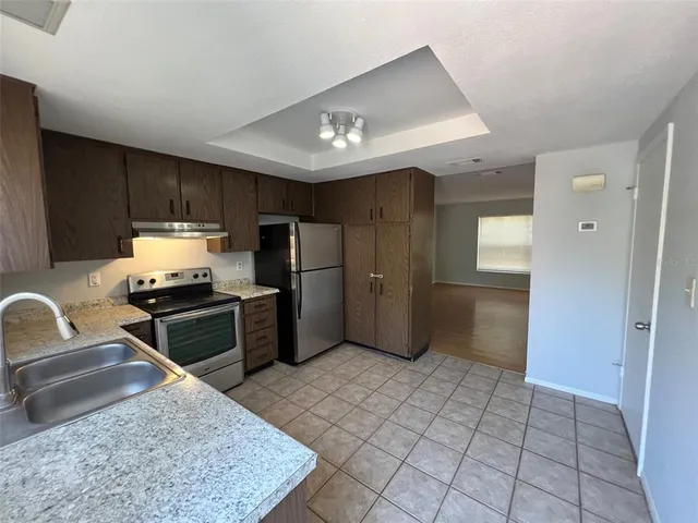 a kitchen with stainless steel appliances granite countertop a refrigerator sink and stove